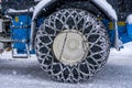 Closeup of a chained wheel of a snowy snow plow on the mountain ski resort in french Alps Royalty Free Stock Photo