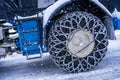 Closeup of a chained wheel of a snowy snow plow on the mountain ski resort in french Alps Royalty Free Stock Photo