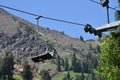 Chairlift in the summertime with mountain slope in background. Royalty Free Stock Photo