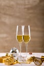 Closeup of champagne flutes by golden novelty glasses and gift boxes on table
