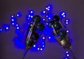 Closeup of glasses full of Christmas  bulbs against blue garland lights on the wall. Royalty Free Stock Photo