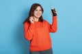 Closeup of charming woman orange jumper and wants to drink soda from bottle smiling lady looks at camera and shows fizzy water