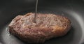 Closeup of checking temperature of ribeye steak in a non stick pan Royalty Free Stock Photo