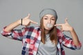 Closeup of cheeky teen girl blowing bubblegum and pointing at it