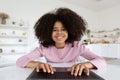Closeup of cheerful black preteen girl typing on laptop keyboard Royalty Free Stock Photo
