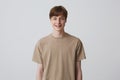 Closeup of cheerful blond handsome young man with healthy teeth and metal braces wears beige t shirt feels happy isolated over Royalty Free Stock Photo