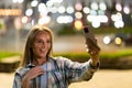 Closeup cheerful girl taking selfie photo by mobile phone on night city street. Portrait of happy woman showing victory sign to Royalty Free Stock Photo