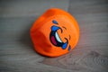 Closeup of a cheerful orange soft toy ball on a wooden floor Royalty Free Stock Photo