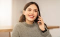Cheerful pretty young brunette woman talking on phone at home Royalty Free Stock Photo