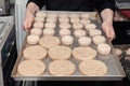 Closeup chef cook hands hold chicken cutlets for burgers. Bread crumbs on metal kitchen tray. Ingredients. Concept restaurant Royalty Free Stock Photo