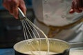 closeup of a chef whisking a creamy emulsion