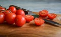 Closeup cherry tomatoes sliced pieces kitchen knife on cutting board Royalty Free Stock Photo