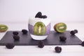 Closeup of chia pudding with blackberries and kiwis on a board under the lights