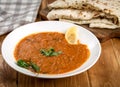Closeup of chicken tikka masala in a white plate with some saj bread in the background Royalty Free Stock Photo