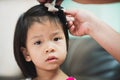 Closeup child face. A mother`s hand is attached to a hairpin for her daughter Royalty Free Stock Photo