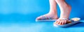 Closeup child feet wearing a pair of fun bright flip-flops on blue background. Kids and family lifestyle outdoors. The concept of Royalty Free Stock Photo