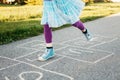 Closeup of child girl playing jumping hopscotch outdoors. Funny activity game for kids on playground outside. Summer backyard