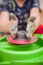 Closeup of child`s hands with potter`s wheel. Kid boy making a bowl of clay at pottery school Royalty Free Stock Photo