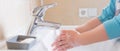 Closeup of a child`s soapy hands being washed under running water in a sink Royalty Free Stock Photo