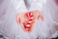 Closeup children`s hands holding Christmas gingerbread in form of caramel can.