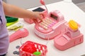 Closeup children`s hands with toy plastic cash register, scales, plastic vegetables, money, play in children`s store at home Royalty Free Stock Photo