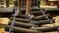 Closeup of childs\' feet walking over wobbly rope bridge at adventure park in summer camp. Kids sports, summer holiday, fun Royalty Free Stock Photo