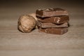 Closeup of chocolate bards and dry walnuts on a wooden surface