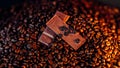 Closeup of chocolate on a pile of roasted coffee beans Royalty Free Stock Photo