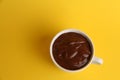 Closeup of chocolate pudding in a cup isolated on a yellow background Royalty Free Stock Photo