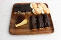 Closeup of choux pastry buns, cheesecake and eclairs on a wooden plate Royalty Free Stock Photo