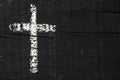 Christian cross on a dark gray wooden surface