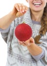 Closeup on christmas ball in hand of young woman in sweater Royalty Free Stock Photo