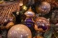 Closeup of Christmas ornament in shape of small gnome girl in glittered blue costume. Santa character bauble among mirrored balls.