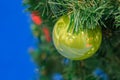 Closeup of Christmas-tree decoration. Decorative green bauble in a fur tree
