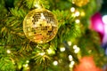 Closeup christmas tree and golden disco ball hanging of Christmas lights and New year