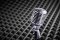 Closeup of chrome retro condenser microphone on acoustic foam panel background