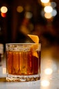 Closeup glass of godfather cocktail with slice of orange and ice cubes at bright bar background Royalty Free Stock Photo