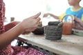 Closeup clay pottery under production with blurred motion hands of little girl in workshop