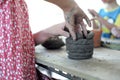 Closeup clay pottery under production with blurred motion hands of little girl in workshop