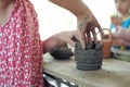 Closeup clay pottery under production with blurred motion hands of little girl in workshop