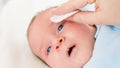 Closeup of cleaning and washing baby's face with soft cottong pad. Concept of babies and newborn hygiene and healthcare Royalty Free Stock Photo