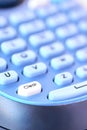 Closeup of a clear button on a blue keyboard.