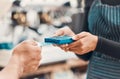 Closeup of a clerk accepting a credit card payment from a customer in a cafe or store. Hands of woman using card machine Royalty Free Stock Photo