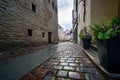 Closeup of cobbled street with old buildings after raining. Royalty Free Stock Photo