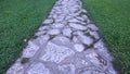 Closeup of a cobbled street and vivid green grass. Grey paving stones. Cobblestones, street, alley, road, path. 