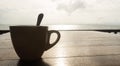 Closeup coffee cup at beach cafe in silhouette Royalty Free Stock Photo