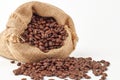 Closeup of Colombian coffee beans in a burlap bag and on the floor isolated on the white background Royalty Free Stock Photo