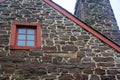 Closeup of colonial american stone home antique window roofline and chimney