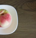 Large peach on a white plate