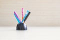 Closeup color pen with black ceramic desk tidy for pen on blurred wood desk and wood wall textured background Royalty Free Stock Photo